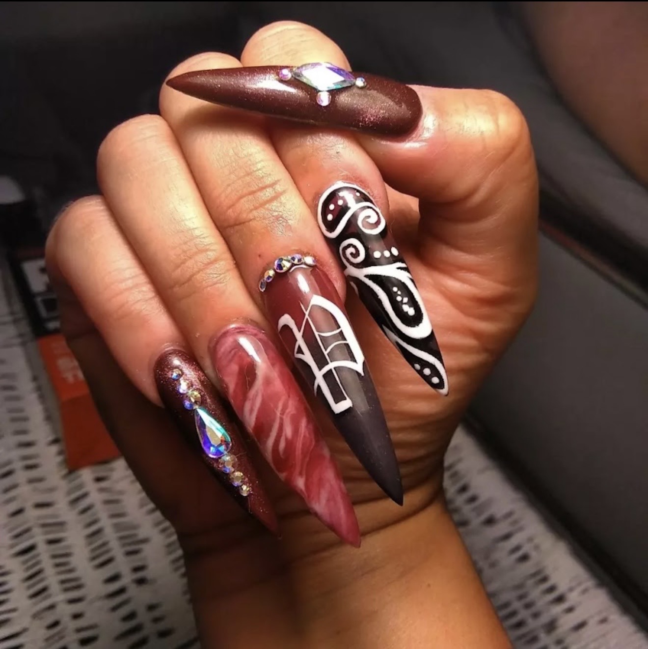 Maroon stiletto nails with gothic art