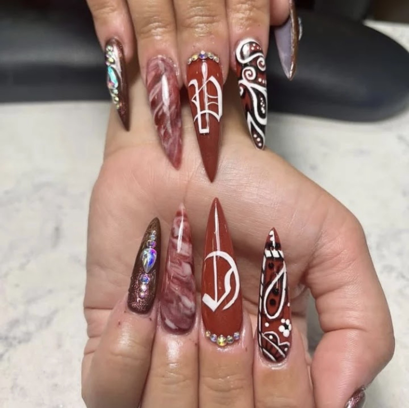 Burgundy stiletto nails with paisley art